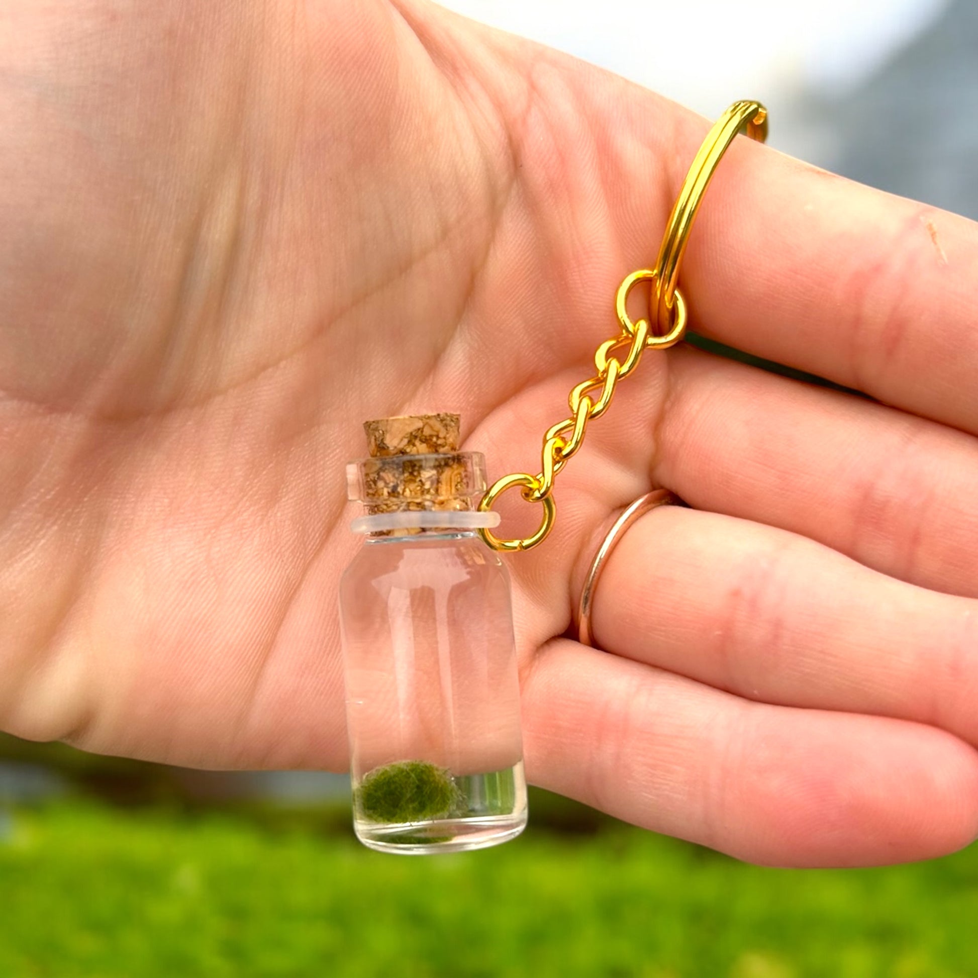 Keychain with Marimo MateS inside a vial and gold keyring